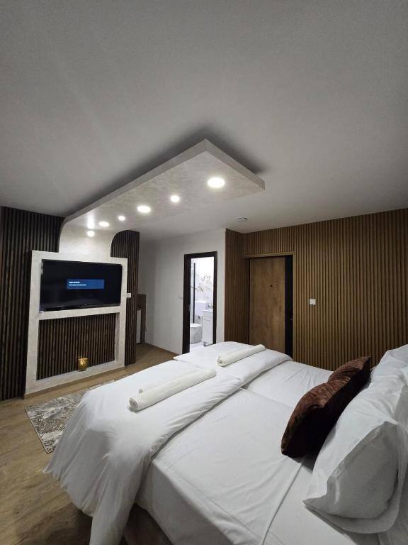 Twin room with flat-screen TV and wood panel wall